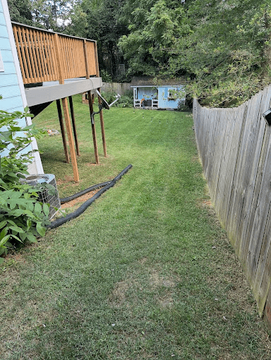 Well-maintained backyard with wooden deck structure and pristine lawn