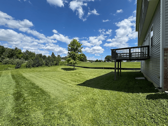 Professional lawn mowing with perfect striping patterns on a large residential property