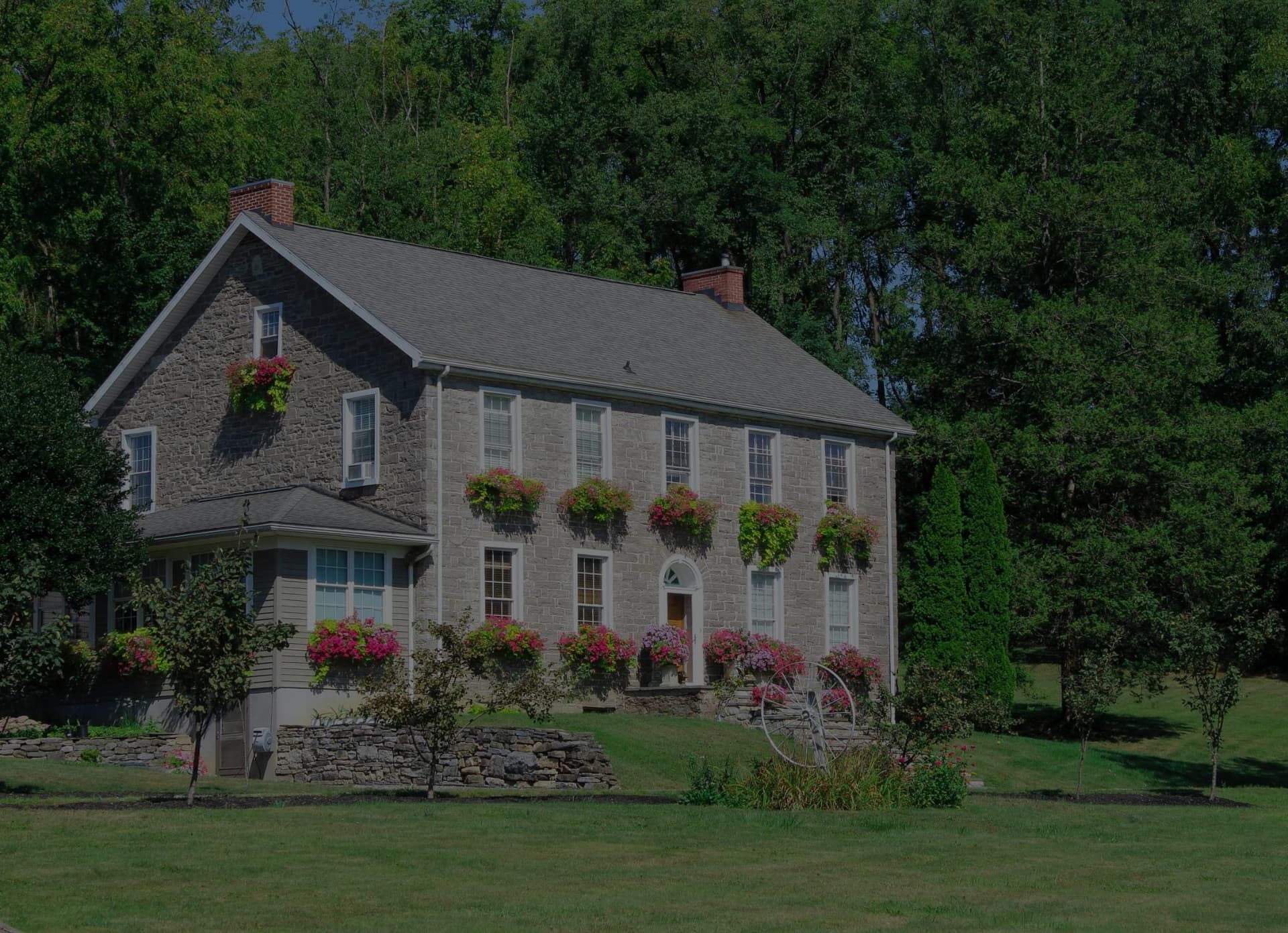 Professional lawn mowing and exterior home maintenance services in Radford, Christiansburg, and Blacksburg Virginia - Beautiful stone home showcasing expert lawn care and maintenance