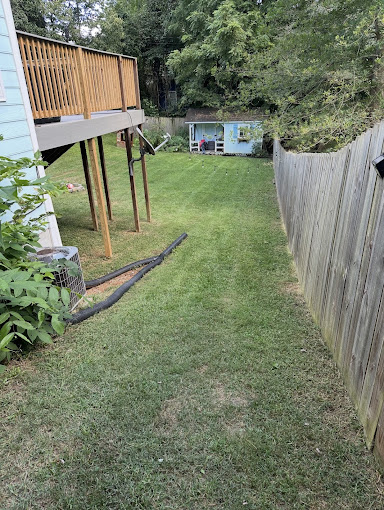 Well-maintained backyard with wooden deck structure and pristine lawn