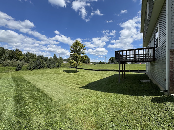 Professional lawn mowing with perfect striping patterns on a large residential property